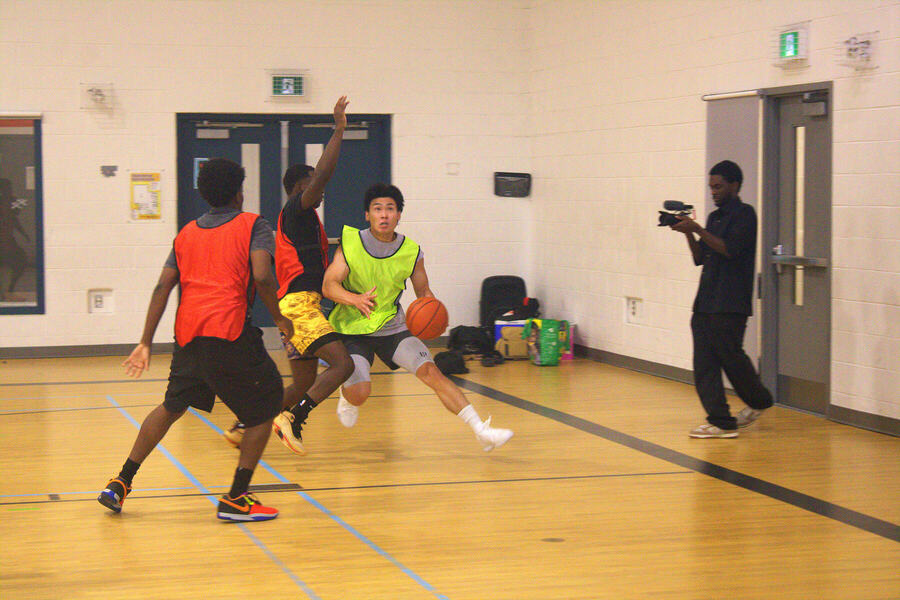 A player driving between two defenders while our videographer films
