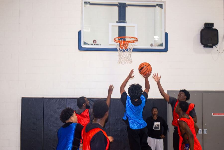 Hands reaching for a rebound under the rim
